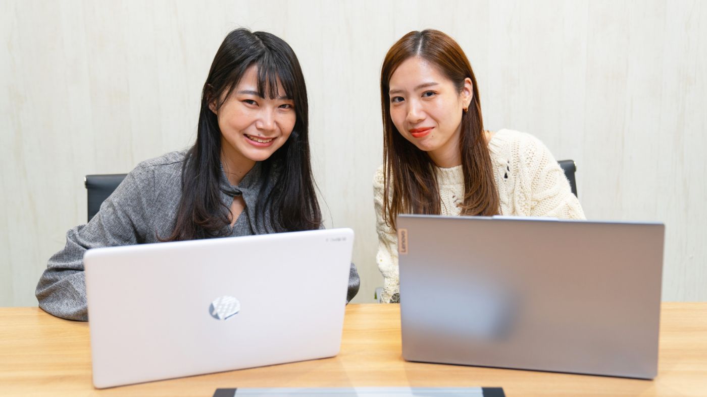 先輩が隣で操作を教えている様子